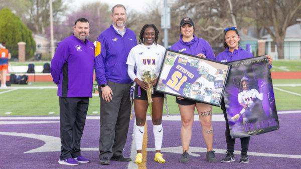 Woman with university representatives at midfield of football